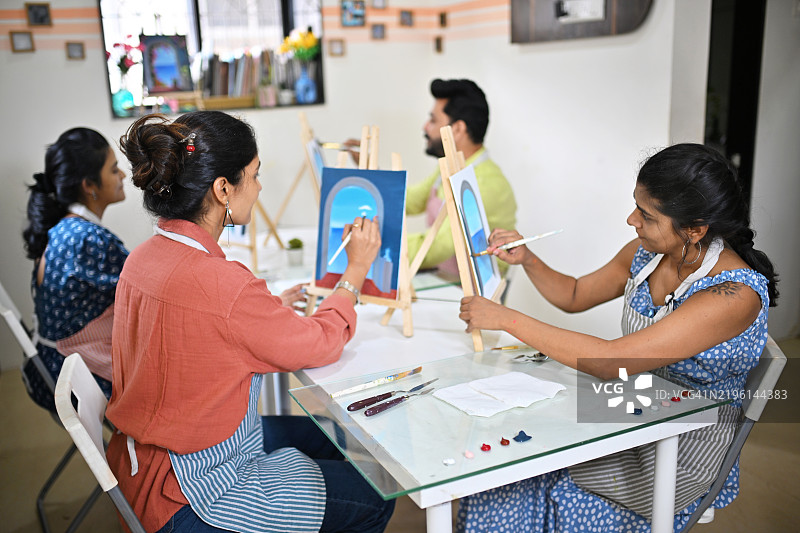 参与者在艺术工作室的画布绘画工作坊中全神贯注。图片素材