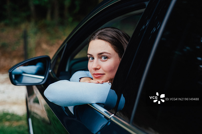 年轻女性购买她的第一辆车。首次购车的概念。图片素材