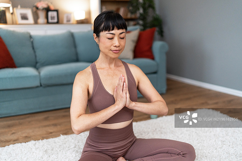 日本女性在家中闭眼冥想。图片素材