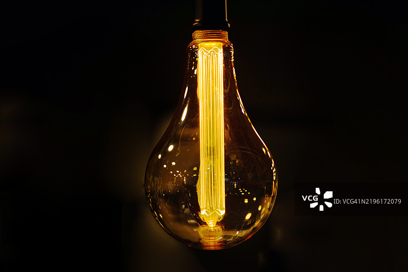 黑色背景上的发光灯泡图片素材