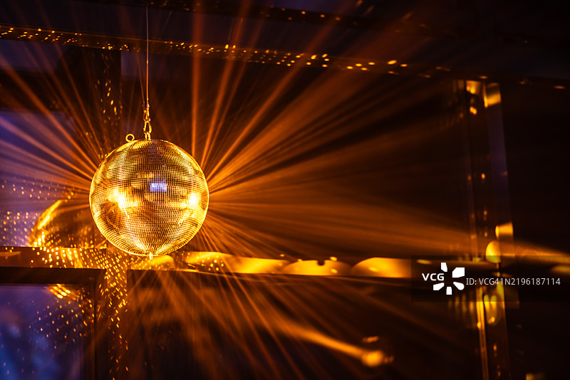 闪亮的迪斯科球在模糊灯光的彩色背景上，留有文字空间。散景效果图片素材