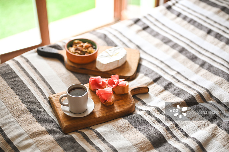 床上享用早晨咖啡和食物。图片素材