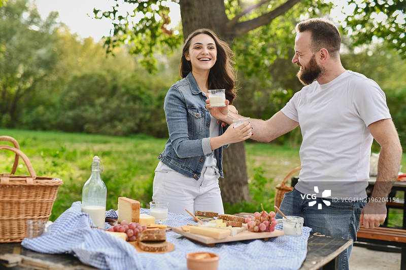 男朋友和女朋友在野餐时开心大笑，享受快乐时光图片素材
