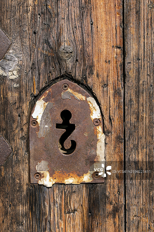 倒置问号形状的钥匙孔,位于意大利利古里亚省萨沃纳的安多拉城堡遗址上的罗曼式教堂圣雅各布和圣菲利普教堂的入口处图片素材