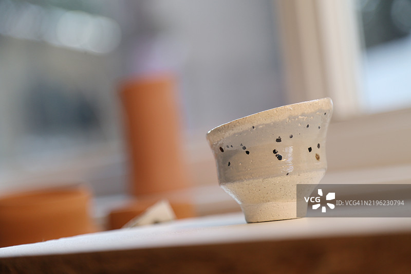 独特形状和鲜艳色彩的手工陶杯特写图片素材