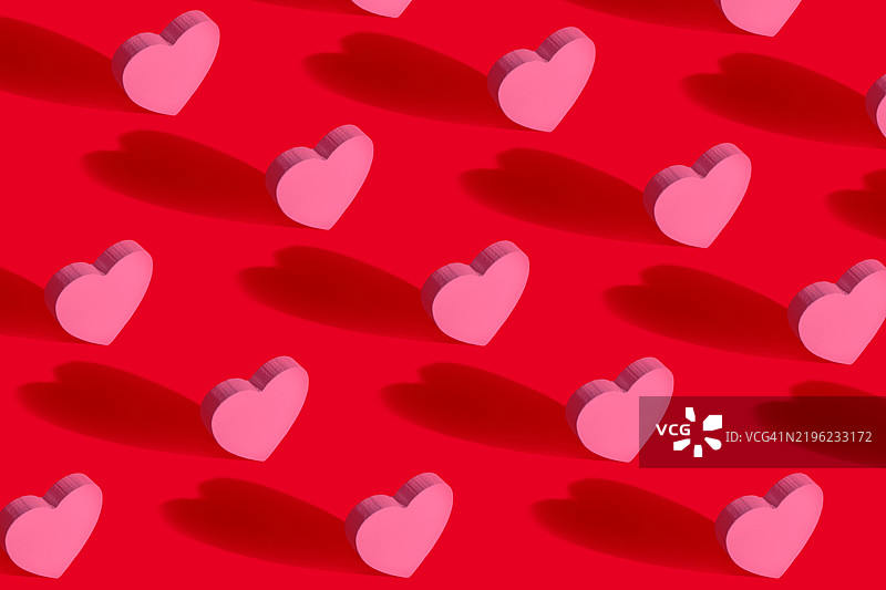 粉色心形在红色背景上投下阴影，形成图案图片素材