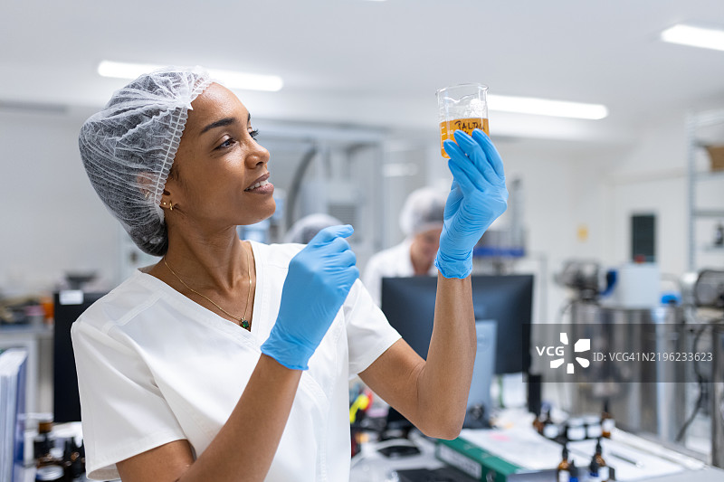 一位女性药剂师在药房中向平板电脑输入数据。图片素材