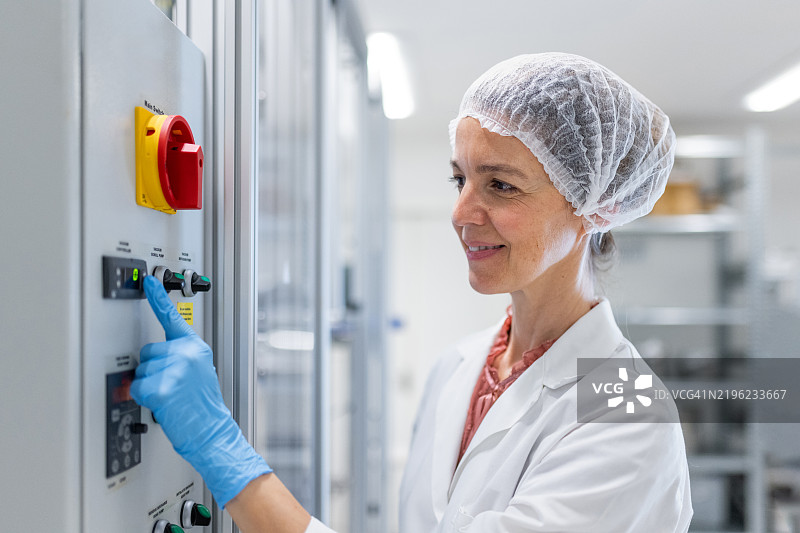 药剂师操作蒸馏系统，用于化妆品的制药生产蒸馏。图片素材