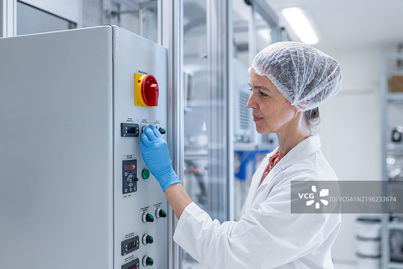 药剂师操作蒸馏系统，用于化妆品的制药生产蒸馏。图片素材