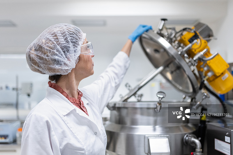 一名女性药品生产工人在工作场所摆姿势图片素材
