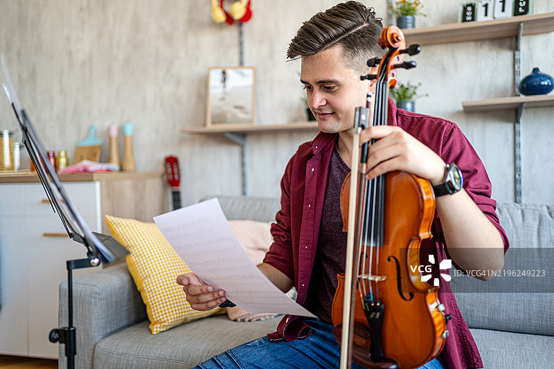 男子小提琴手在阅读乐谱图片素材