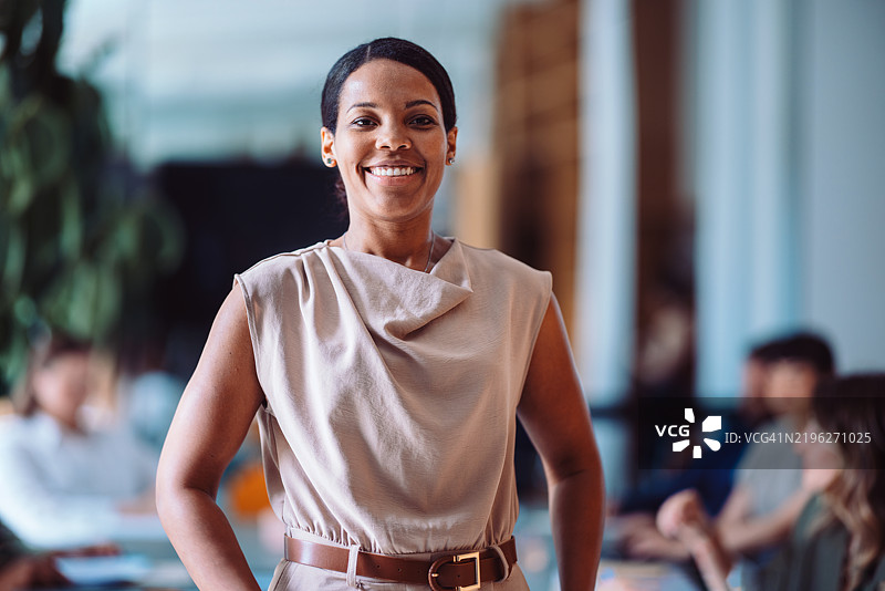 自信的职业女性在现代商务办公室环境中灿烂微笑图片素材