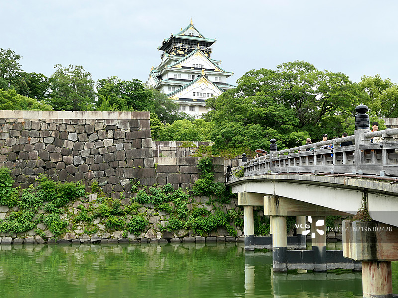 在日本大阪的乐园桥上，人们与大阪城同框。图片素材