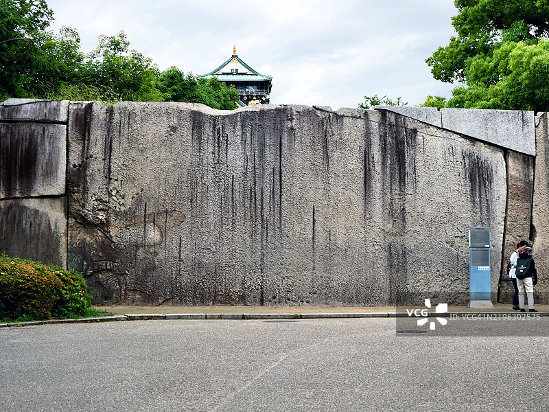 在日本大阪，背景是大阪城的章鱼石上的人们图片素材
