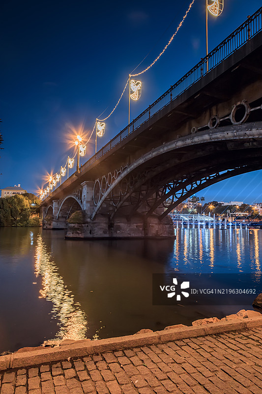 特里亚纳桥在夜晚闪烁着圣诞灯光，安达卢西亚，西班牙。图片素材