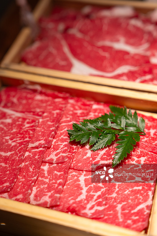 切好的牛肉片放在竹制盘子里，适合涮涮锅和火锅使用图片素材