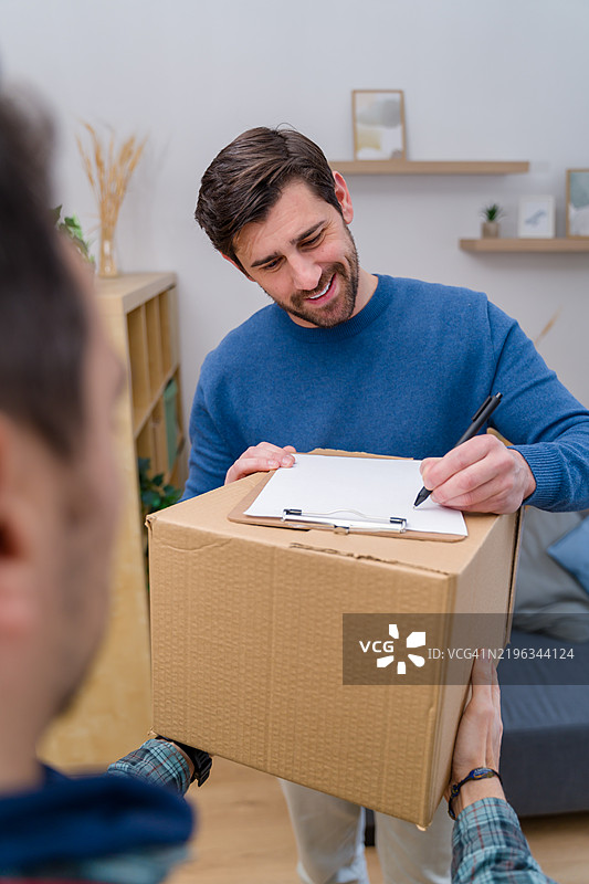 快递员将包裹递给顾客图片素材