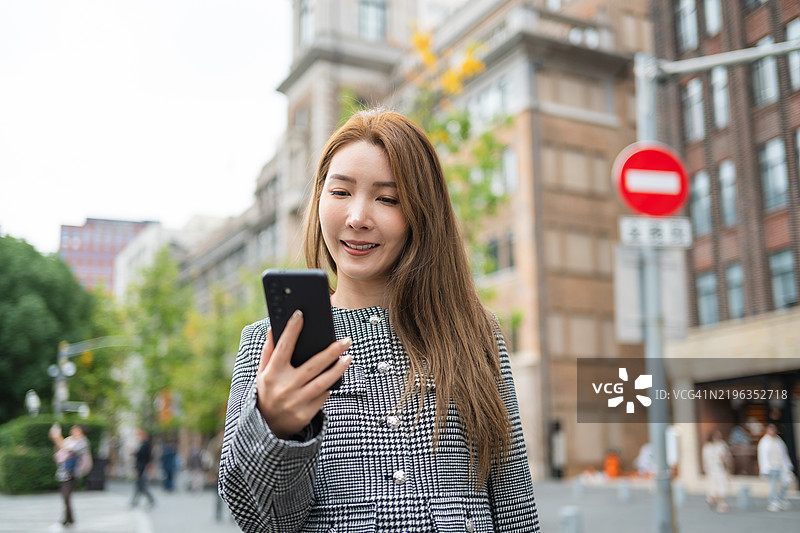 亚洲女性在上海外滩使用智能手机图片素材