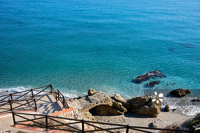 通往隐秘海滩的木制楼梯，海水呈现出碧绿色。图片素材