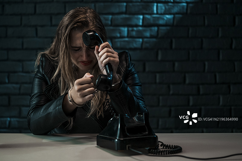 被铐住的痛苦女性正在打电话图片素材