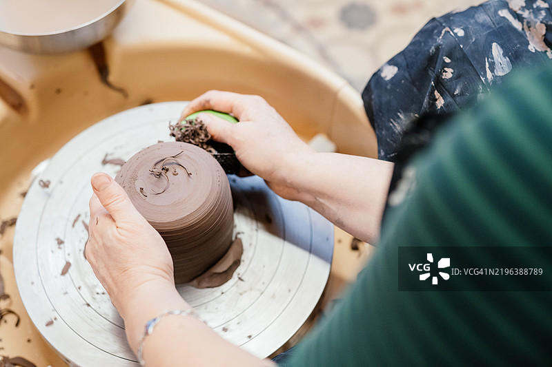 女性在陶艺轮和工具上制作陶器的背影图像图片素材