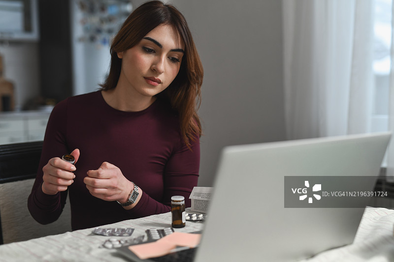 女性在视频通话中与朋友交谈时服用流感药物的场景图片素材