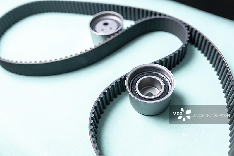 薄荷绿背景上的时序带和齿轮特写图片素材