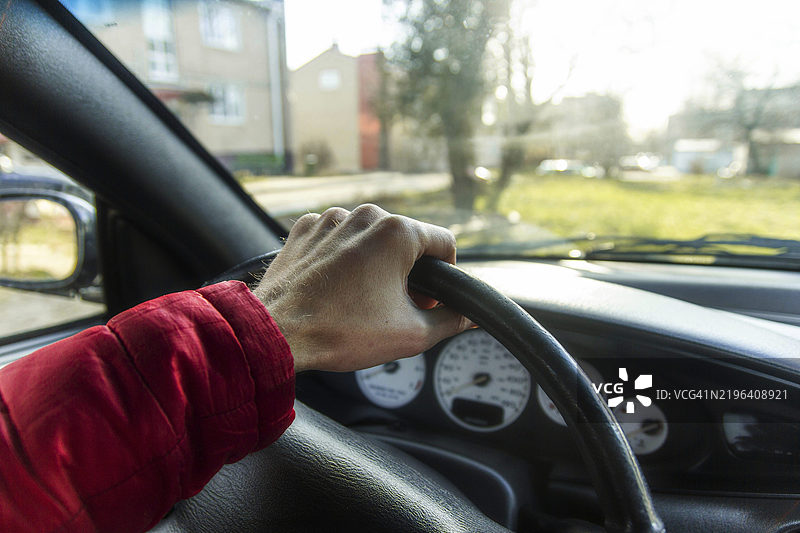 早晨驾驶，聚焦于方向盘和窗外的社区景观图片素材