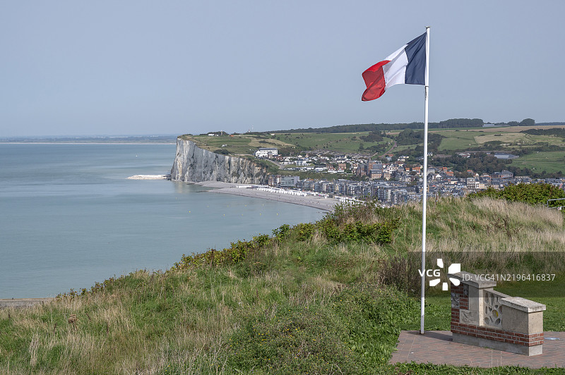 法国国旗在勒特雷波特的阿尔巴特海岸悬崖顶观景点的风中飘扬，俯瞰渔镇及其白垩悬崖海岸，塞纳-马恩省，诺曼底，法国，欧洲图片素材