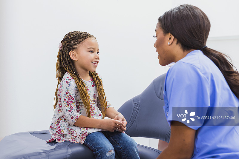 医生与年轻女孩在医疗检查中交谈图片素材