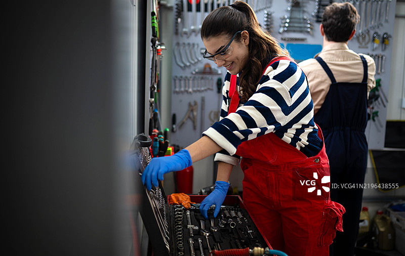 女性在汽车修理店修理汽车图片素材