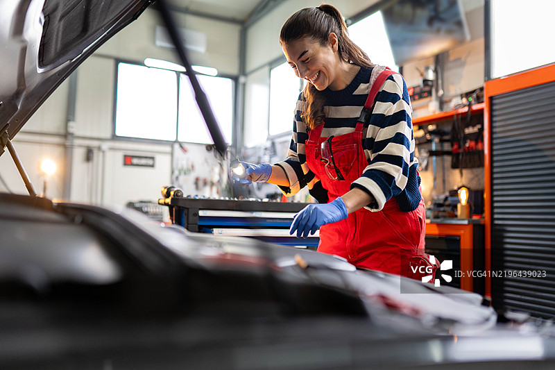 女性在汽车修理店修理汽车图片素材