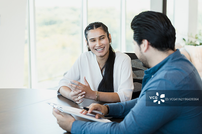 两位同事在商务会议中讨论图片素材