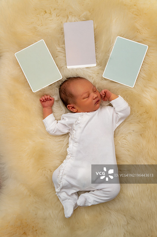 一个混血婴儿在毛茸茸的地毯上睡觉。图片素材