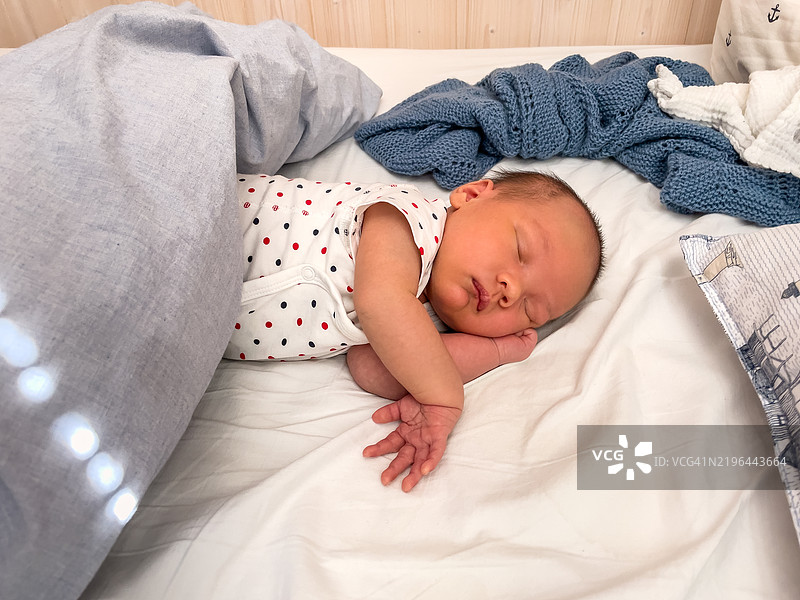 一个新生儿在舒适的床上睡觉。图片素材