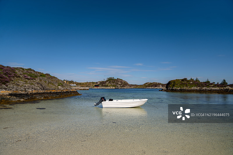 一艘船停靠在挪威奥斯特海姆的美丽索尤纳岛海岸旁。图片素材