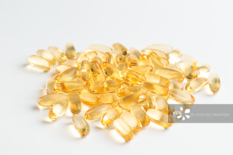 白色背景上的Omega 3或D维生素胶囊，黄色鱼油胶囊，预防心脏病和缺血性中风，护肤，抑郁症治疗。图片素材