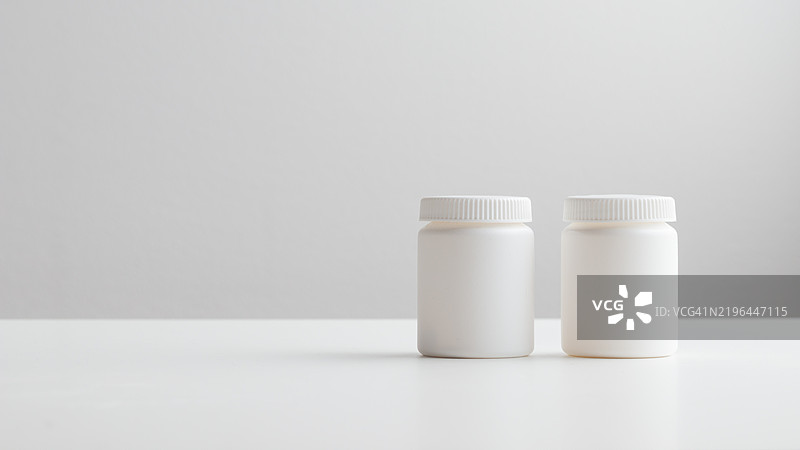 白色背景上的白色塑料药瓶，留有空白空间。药物和健康概念包括装有药丸或维生素的瓶子。高质量的照片横幅。图片素材