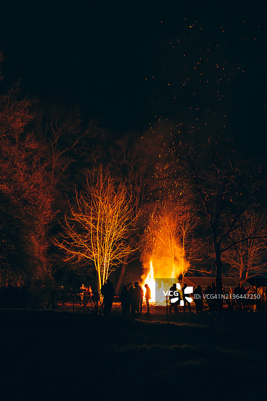 夜间户外环境中朋友们围绕篝火的剪影图片素材