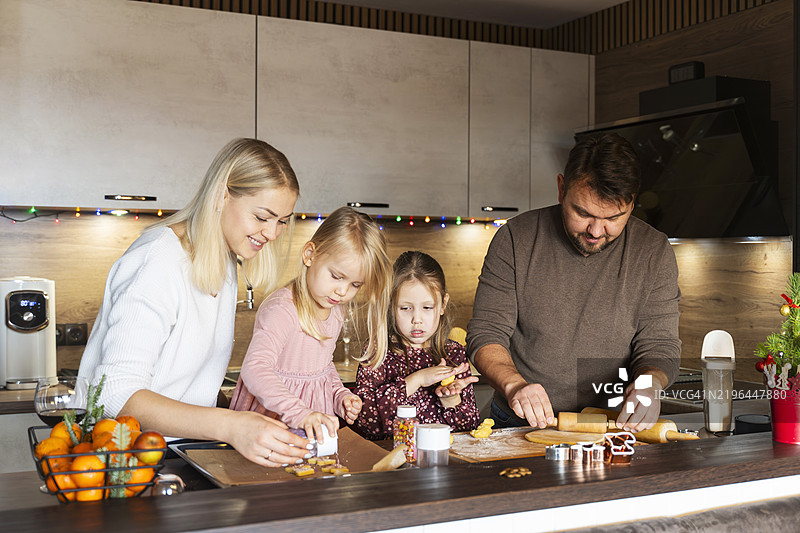 父母在家帮助孩子们制作圣诞饼干图片素材