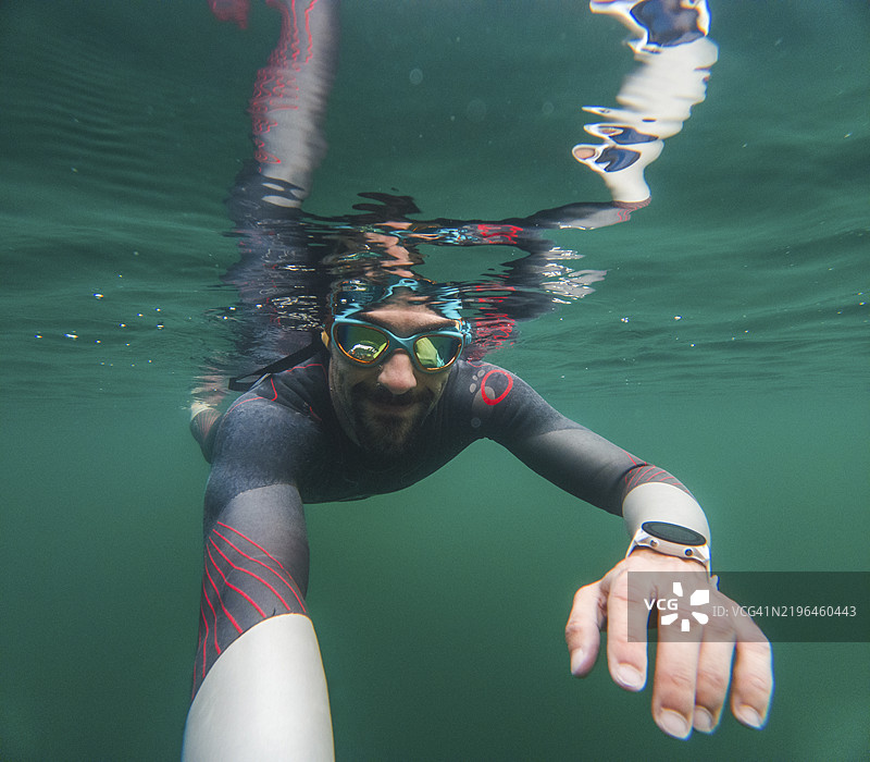 穿着潜水服的游客在水下自拍游泳图片素材