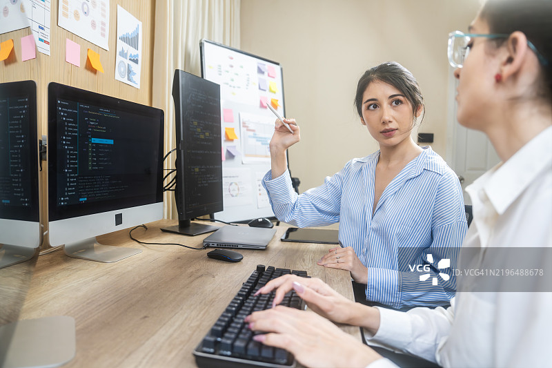 两位专业人士在电脑工作站上合作项目图片素材