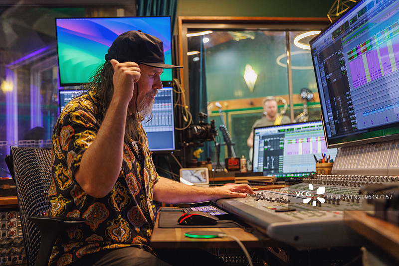 在录音室工作的音响工程师/音乐制作人图片素材