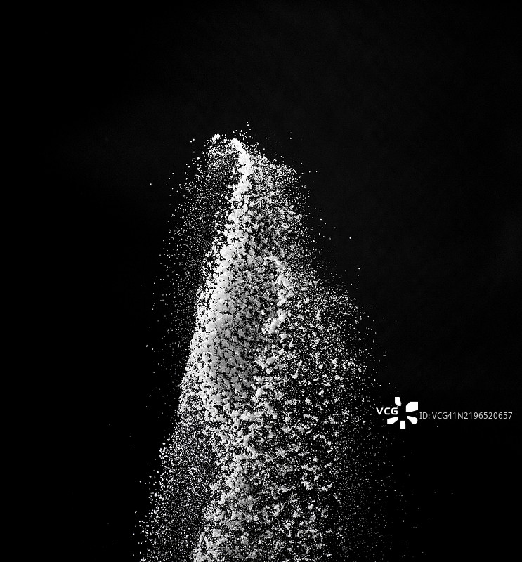黑色背景上，厨房盐颗粒呈上升状态的云彩。图片素材