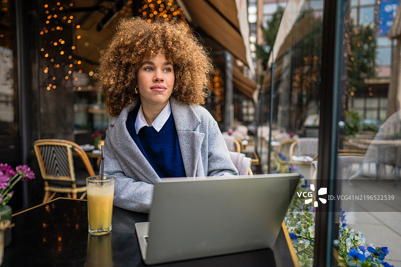 年轻女性在户外咖啡馆工作图片素材