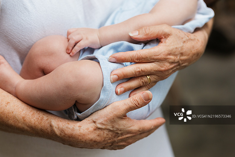 祖母温柔而坚定地抱着她的孙子。图片素材
