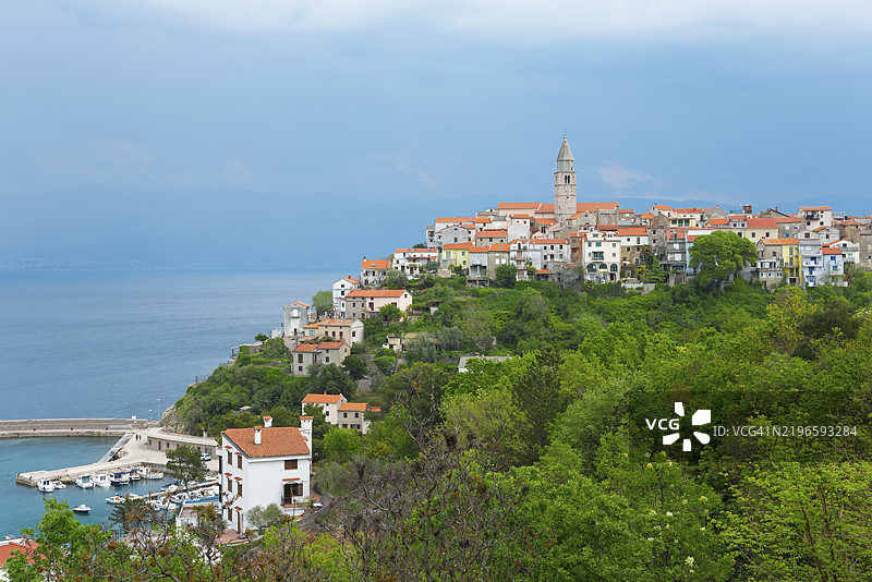 克瓦尔内尔湾的克尔克岛维尔布尼克，海岸小镇，红陶色屋顶、教堂和港口，前方是茂密的丘陵景观。图片素材