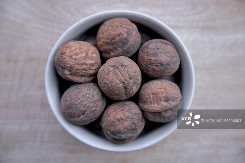 白碗中的印度胡桃平铺，乡村自然食品，干果，俯视图图片素材