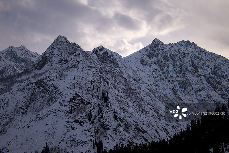 被雪覆盖的山峰与紫色云彩，傍晚，巴基斯坦北部图片素材