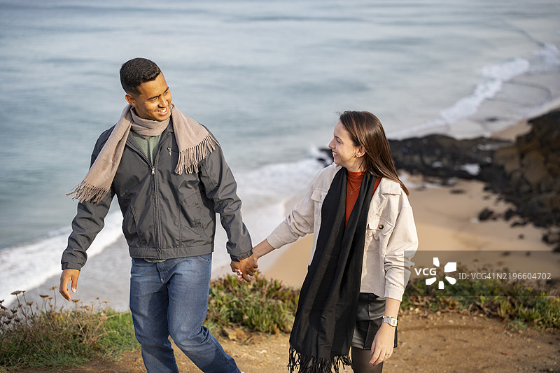 情侣在海滩上手牵手散步图片素材